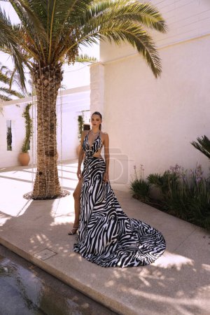 Photo for Fashion outdoor photo of beautiful sensual woman with dark hair in luxurious dress with zebra print posing in luxury lounge in Cyprus - Royalty Free Image