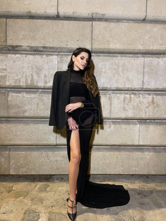 Téléchargez les photos : Photo extérieure de mode de belle femme aux cheveux foncés en robe noire luxueuse et accessoires posant par le pont Alexandre III à Paris - en image libre de droit