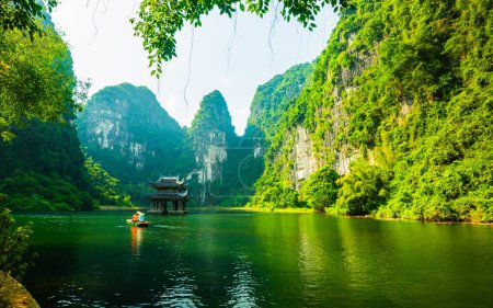 Photo for Floating boat rowling around temple on the lake, sorrounded by mountain at Trang An - Royalty Free Image