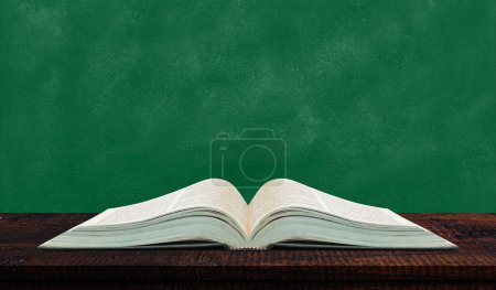 Téléchargez les photos : Livre ouvert placé sur une table en bois avec mur vert - en image libre de droit