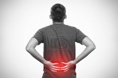 Foto de Hombre que sufre de dolor de espalda aislado sobre fondo gris - Imagen libre de derechos