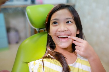 Photo for This cute girl is getting ready for her regular dental appointment at the dentist's office checkup.pediatric medical care concept. - Royalty Free Image
