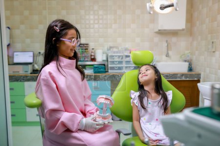 Photo for This cute girl is getting ready for her regular dental appointment at the dentist's office checkup.pediatric medical care concept. - Royalty Free Image