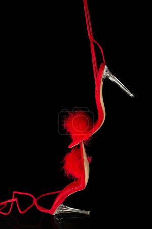 sexy, rote Riemchenschuhe mit hohem Absatz auf schwarzem Hintergrund