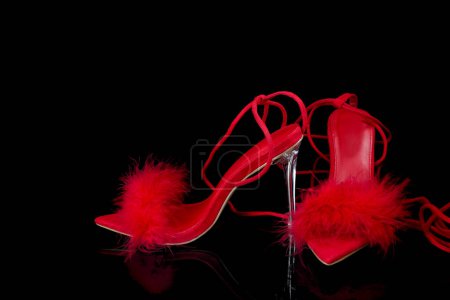 sexy, zapatos de tacón alto de tiras rojas sobre un fondo negro