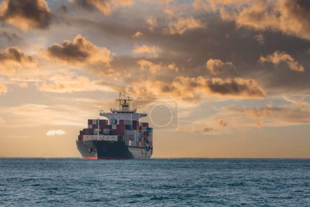 Téléchargez les photos : Navire cargo dans la mer avec un ciel spectaculaire et un fond nuageux. - en image libre de droit