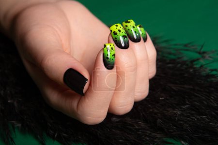 Téléchargez les photos : Female neat hand with short natural nails painted with green nail polish. Natural, cozy, elegant, modern look. High-quality photo - en image libre de droit