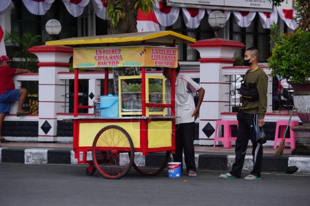 Foto de Es pleret vendedor (pleret hielo) en la carretera lateral. Es pleret es una bebida tradicional indonesia, que utiliza azúcar de palma y leche de coco. - Imagen libre de derechos