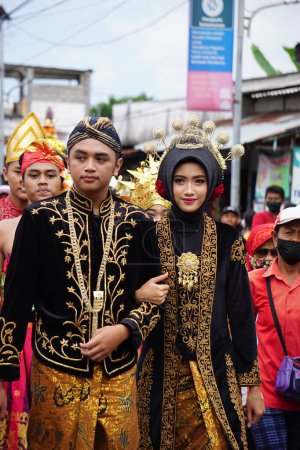 Foto de Indonesian with traditional wedding costumes at a celebration of grebeg pancasila. Grebeg Pancasila is held to celebrate Pancasila day - Imagen libre de derechos