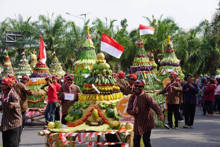 Téléchargez les photos : Kirab tumpeng hasil bumi (action de grâces des fermiers) pour célébrer la fête de l'indépendance indonésienne à Xoang lima gumul Kediri - en image libre de droit