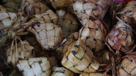 Téléchargez les photos : Ketupat est un plat typiquement indonésien fait de riz, enveloppé dans des feuilles de noix de coco et bouilli dans de l'eau chaude et généralement mangé sur idul fitri - en image libre de droit