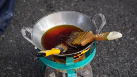 Photo for The wax (Indonesian call it malam) melts in the pan. This wax is used in the process of making batik cloth - Royalty Free Image