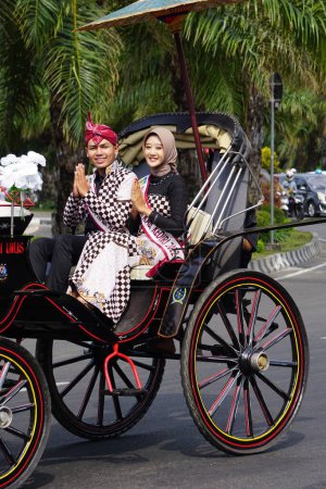 Photo pour Inu kirana (ambassadeur du tourisme de Kediri) sur la calèche à cheval pour célébrer la fête indonésienne de l'indépendance à Xoang lima gumul kediri - image libre de droit