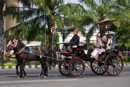 Photo pour Inu kirana (ambassadeur du tourisme de Kediri) sur la calèche à cheval pour célébrer la fête indonésienne de l'indépendance à Xoang lima gumul kediri - image libre de droit