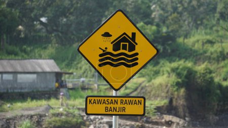 Téléchargez les photos : Panneau jaune avec un fond naturel. Kawasan rawan banjir signifie zone inondable - en image libre de droit