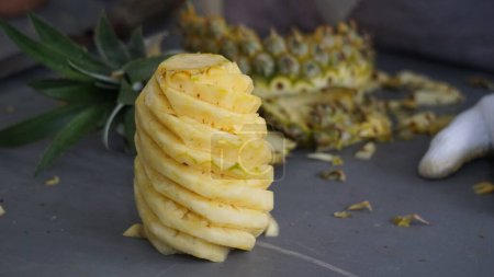 Téléchargez les photos : Fruit vendeur peler ananas pour les acheteurs - en image libre de droit