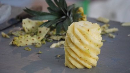 Téléchargez les photos : Fruit vendeur peler ananas pour les acheteurs - en image libre de droit