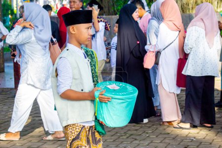 Téléchargez les photos : Les Indonésiens recueillent des fonds auprès de la communauté lorsqu'ils prient l'Aïd al-Fitr à la mosquée - en image libre de droit