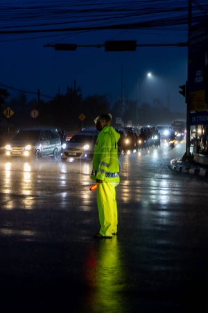 Photo for Police regulate vehicle traffic when it rains at night - Royalty Free Image