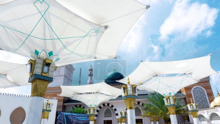 Großer Regenschirm in der Moschee vor blauem Himmel