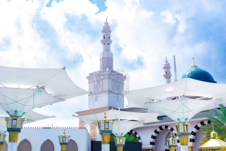 Großer Regenschirm in der Moschee vor blauem Himmel