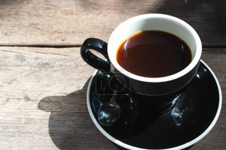 Téléchargez les photos : Vue du dessus du café Amerucano chaud en tasse en céramique noire sur fond en bois. - en image libre de droit