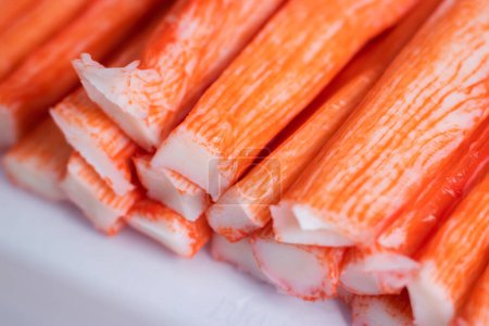 Photo for Close-op of frozen crab sticks in a row, which show the details of red and white meat. - Royalty Free Image