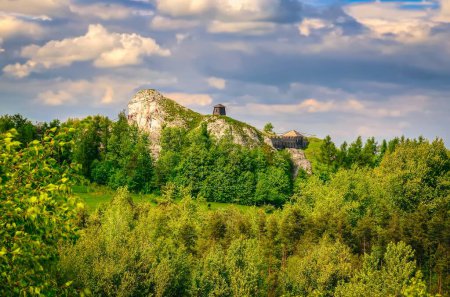 Téléchargez les photos : Paysage des hautes terres dans les paysages d'été. Homme grimpant sur un rocher calcaire jurassique, situé dans la région montagneuse du Jura en Pologne. - en image libre de droit