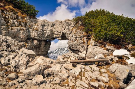 Photo for Rocky arch in Austrian Alps. View over mountains from rock window in Loser peak, Dead Mountains (Totes Gebirge) in Austrian Alps. - Royalty Free Image