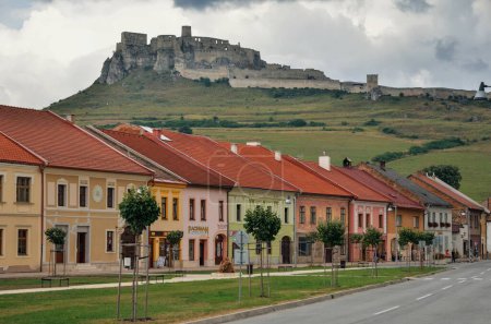 Photo for Spisske Podhradie, Slovakia - August 18, 2015: Old houses and shops with Spissky Hrad Castle in the background in the center Spisske Podhradie Twon, Slovakia. - Royalty Free Image