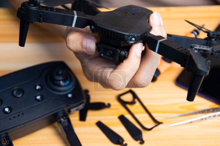 Téléchargez les photos : Mécanicien professionnel réparant un drone sur la table avec divers outils dans un atelier moderne - en image libre de droit