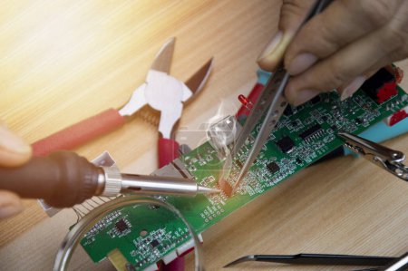Téléchargez les photos : Technicien est la réparation des cartes mères et du matériel de brasage, la réparation des circuits. - en image libre de droit