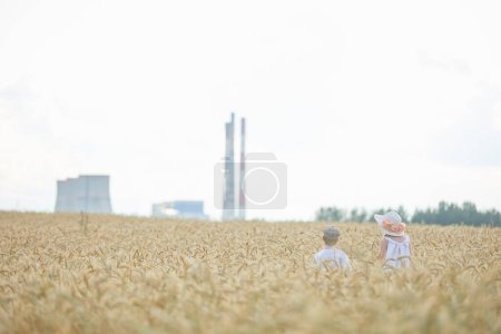 Foto de Vista posterior de niño y niña en sombreros de pie en el campo de trigo - Imagen libre de derechos