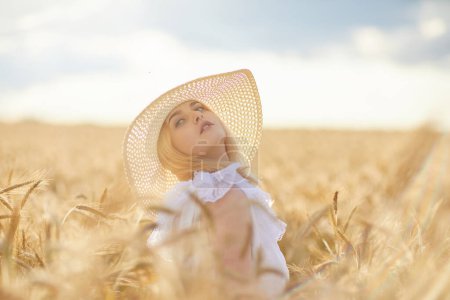 Téléchargez les photos : Portrait de femme heureuse en chapeau, posant dans le champ de blé - en image libre de droit