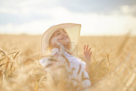 Photo for Portrait of happy woman in hat, posing in wheat field - Royalty Free Image