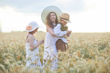 Foto de Madre con hijos posando en el campo de trigo - Imagen libre de derechos