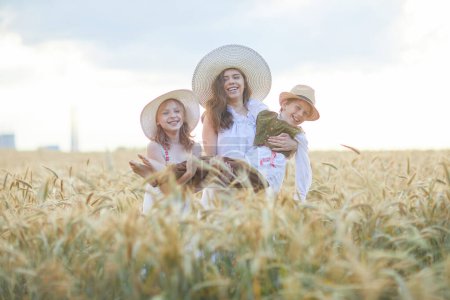 Foto de Madre con hijos posando en el campo de trigo - Imagen libre de derechos
