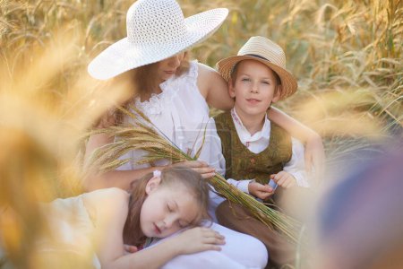 Téléchargez les photos : Mère avec des enfants posant dans le champ de blé - en image libre de droit