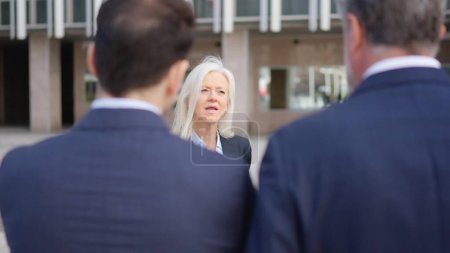 Photo for Slow motion video of an angry senior businesswoman scolding her employees in the street - Royalty Free Image