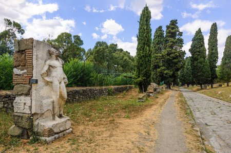 Vista del famoso Camino Appio con una estatua de un heroico desnudo en primer plano