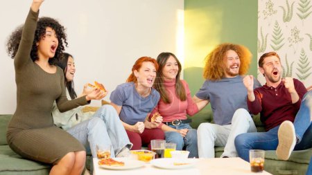Téléchargez les photos : Des amis multiethniques mangeant des pizzas et célébrant la victoire de leur équipe - en image libre de droit