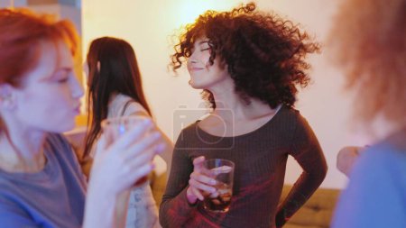 Photo for Multi-ethnic friends dancing and drinking in a home party night - Royalty Free Image