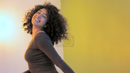 Photo for Latin woman dancing with sensual movements in a home party - Royalty Free Image