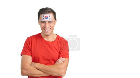 Hombre de pie con bandera de Corea del Sur pintado en la cara sonriendo con los brazos cruzados