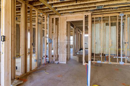 Photo for Installation of mineral fiberglass wool between beams to be used in constructing wall is intended to provide thermal and sound insulation - Royalty Free Image