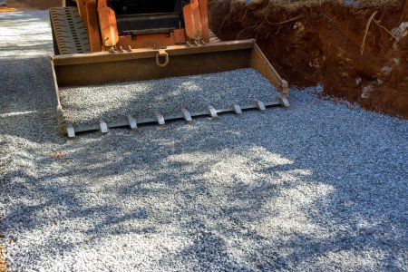 Foto de Bobcat excavadora cargadora se utilizó en el sitio de construcción con el fin de descargar la piedra triturada durante las reparaciones de carreteras. - Imagen libre de derechos