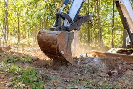 Téléchargez les photos : À l'aide de tracteurs skid steers équipement lourd terrain a été débarrassé des racines pour lotissement de construction - en image libre de droit