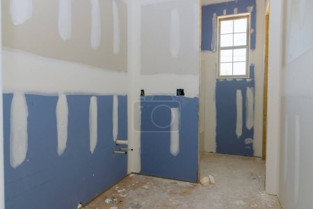 Téléchargez les photos : Une maison nouvellement construite en cours de plâtrage cloisons sèches est prêt pour la peinture - en image libre de droit