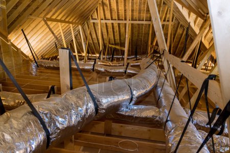 Foto de En casa de nueva construcción en construcción tubos de ventilación son material de aislamiento de plata en el techo del ático - Imagen libre de derechos