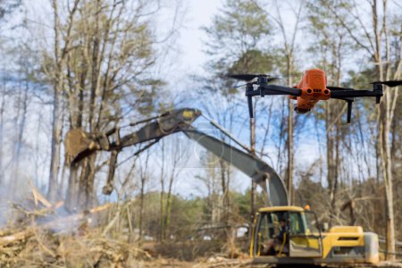 Téléchargez les photos : Les services d'incendie utilisent des drones pour surveiller le déracinement contrôlé des arbres sur les chantiers de construction. - en image libre de droit